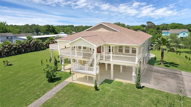 1004 8th St, San Leon, TX 77539 - rear view of property featuring a yard, stairs, concrete driveway, a porch, and roof with shingles
