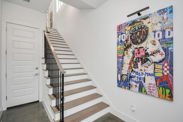 stairs with concrete floors and baseboards