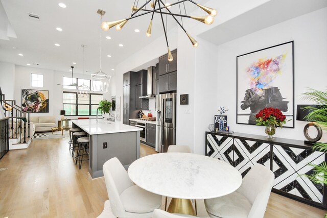 dining area featuring a chandelier, recessed lighting, and light wood-type flooring