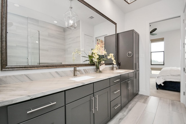 ensuite bathroom with double vanity, recessed lighting, a ceiling fan, and tiled shower