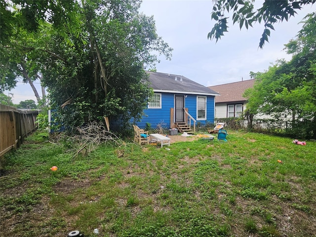 back of house featuring fence and entry steps