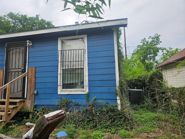 view of side of property featuring central air condition unit and entry steps