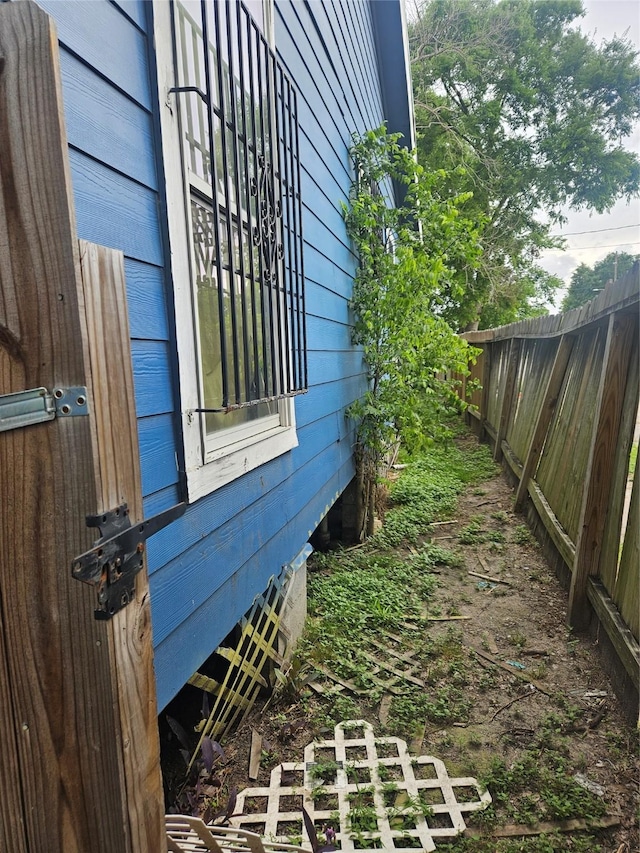 view of side of home featuring fence