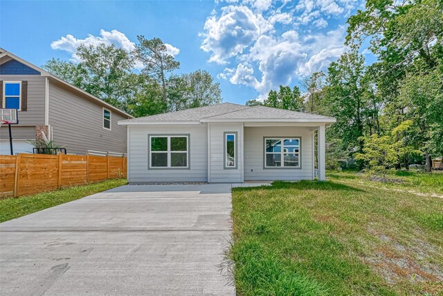 bungalow with fence, driveway, and a front lawn