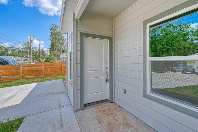 property entrance with a patio area and fence