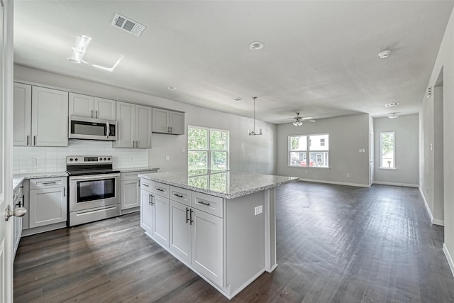 kitchen with visible vents, baseboards, appliances with stainless steel finishes, and a wealth of natural light