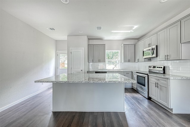 kitchen featuring gray cabinetry, a center island, stainless steel appliances, and visible vents