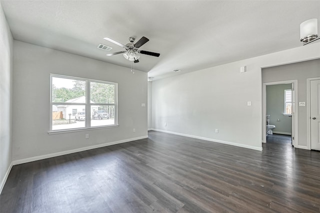 spare room with visible vents, dark wood finished floors, ceiling fan, and a healthy amount of sunlight
