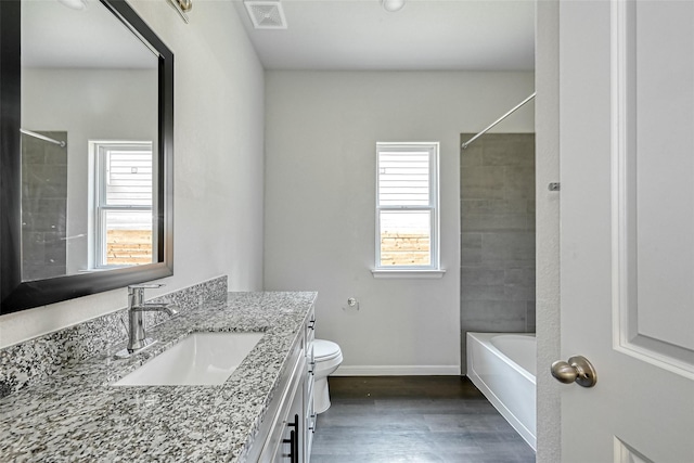 bathroom featuring vanity, plenty of natural light, toilet, and visible vents