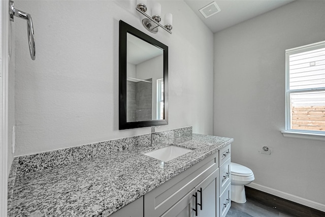 full bathroom with visible vents, wood finished floors, baseboards, vanity, and toilet