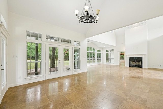 12061 Oak Forest Ln, Conroe, TX 77385 - unfurnished living room with a high ceiling, french doors, a chandelier, baseboards, and a fireplace