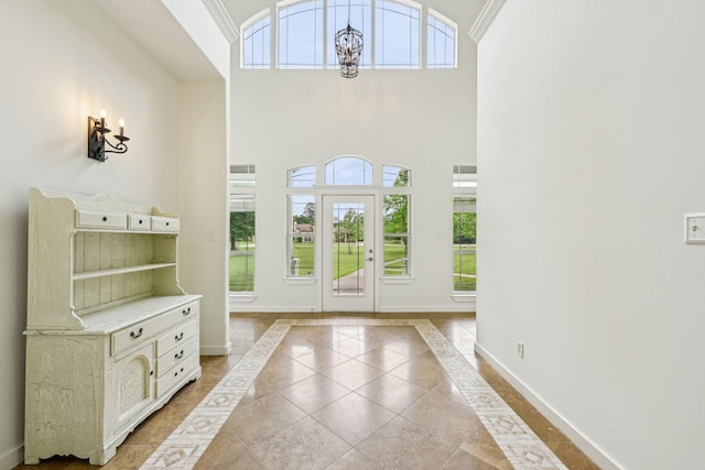 entrance foyer with baseboards, light tile patterned floors, and high vaulted ceiling