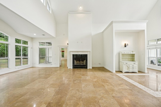 12061 Oak Forest Ln, Conroe, TX 77385 - unfurnished living room with a high ceiling, healthy amount of natural light, a fireplace, and baseboards