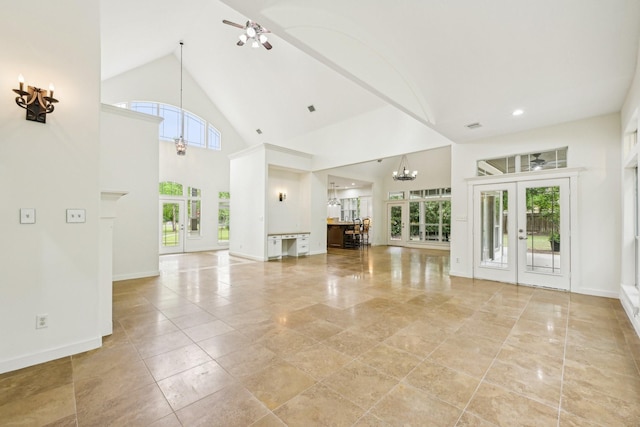 12061 Oak Forest Ln, Conroe, TX 77385 - unfurnished living room featuring plenty of natural light, a ceiling fan, french doors, a chandelier, and high vaulted ceiling