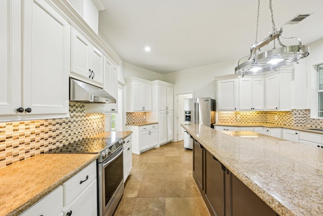 12061 Oak Forest Ln, Conroe, TX 77385 - kitchen with appliances with stainless steel finishes, under cabinet range hood, decorative backsplash, white cabinetry, and recessed lighting
