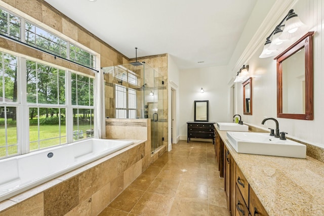 bathroom with a garden tub, a sink, a stall shower, and double vanity