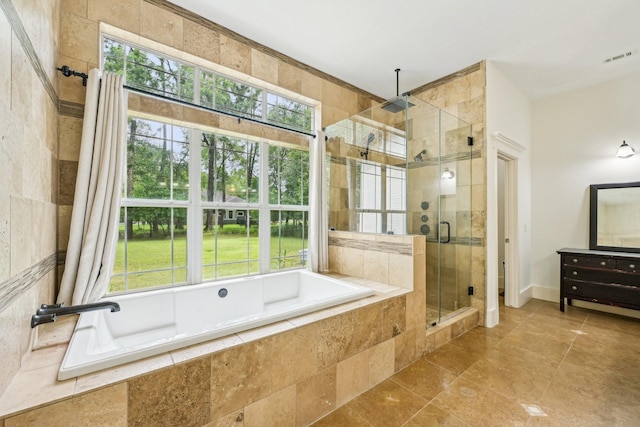 bathroom with tile patterned flooring, plenty of natural light, a stall shower, and a garden tub