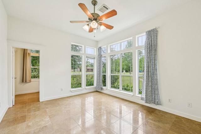 empty room with visible vents, baseboards, and ceiling fan