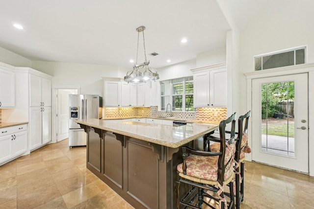 kitchen featuring a kitchen island, stainless steel appliances, decorative backsplash, and white cabinetry