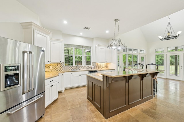 12061 Oak Forest Ln, Conroe, TX 77385 - kitchen featuring stainless steel appliances, french doors, a chandelier, tasteful backsplash, and white cabinets