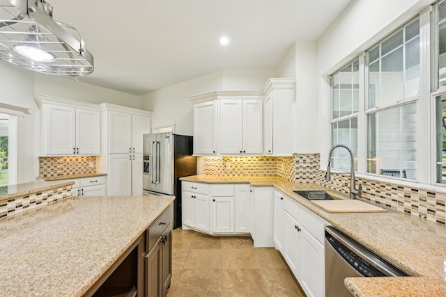 kitchen with a sink, appliances with stainless steel finishes, and white cabinetry