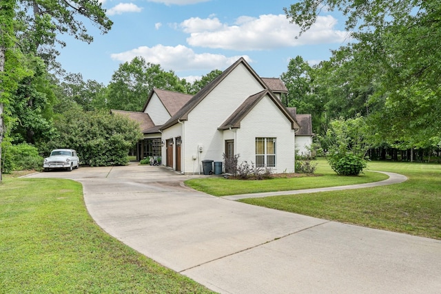 view of front of house with brick siding, a shingled roof, a front lawn, and concrete driveway