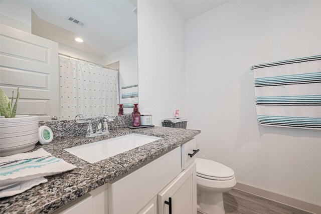bathroom with visible vents, wood finished floors, vanity, baseboards, and toilet