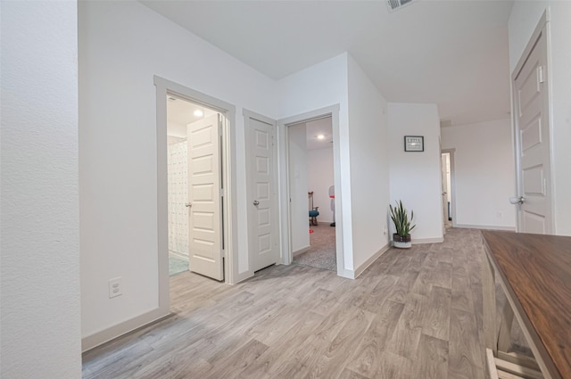 interior space with baseboards and light wood finished floors