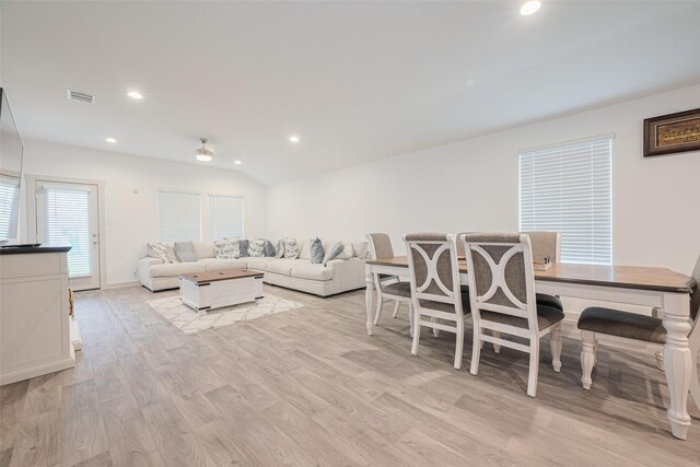 living area featuring visible vents, baseboards, recessed lighting, light wood finished floors, and vaulted ceiling