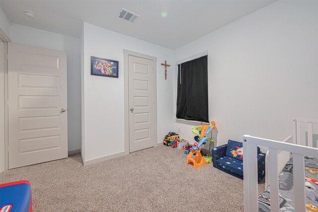 bedroom with visible vents, carpet, baseboards, and a nursery area