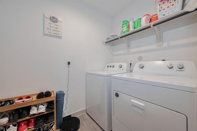 washroom featuring laundry area, light wood finished floors, baseboards, and washer and dryer