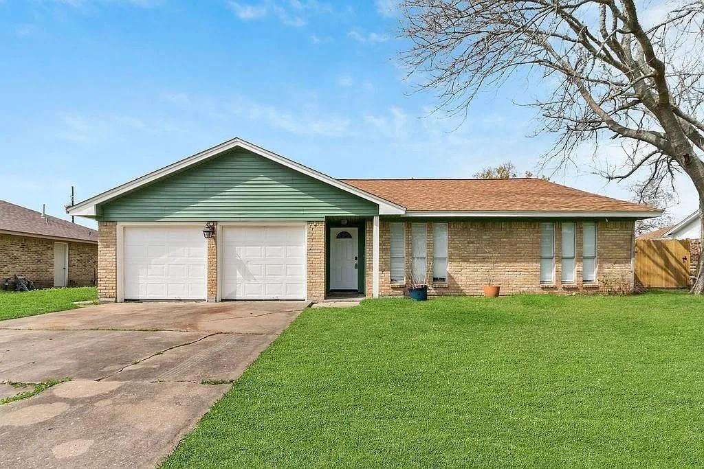 single story home featuring a garage, fence, a front lawn, concrete driveway, and brick siding
