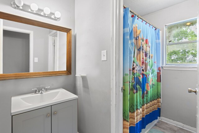 bathroom featuring vanity, baseboards, and a shower with shower curtain