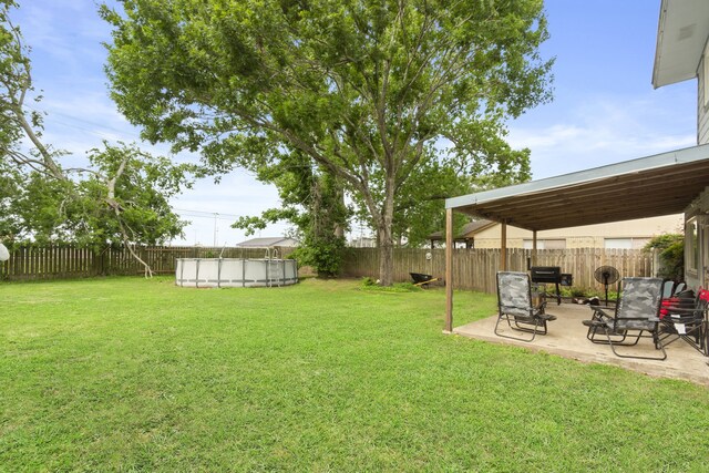 view of yard featuring a patio, a fenced in pool, and a fenced backyard