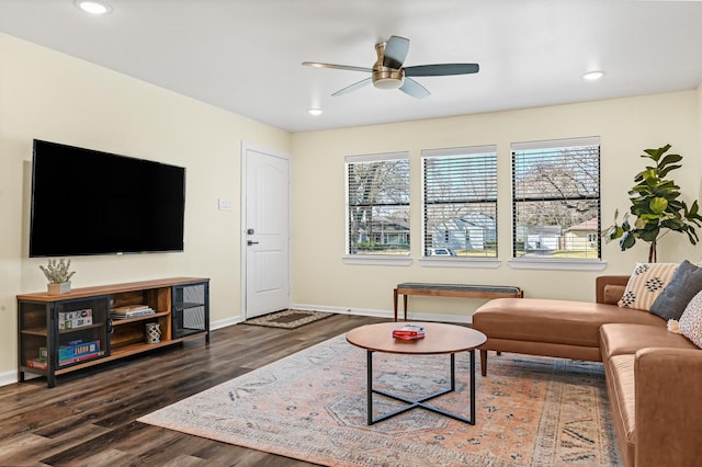 living area featuring baseboards, wood finished floors, and a ceiling fan