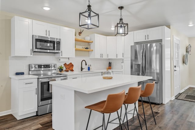 kitchen with a breakfast bar, a sink, stainless steel appliances, decorative backsplash, and a kitchen island