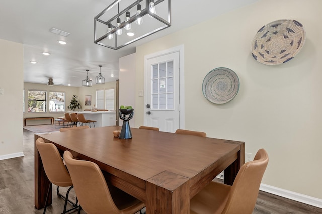 dining area with ceiling fan with notable chandelier, dark wood-type flooring, baseboards, visible vents, and recessed lighting