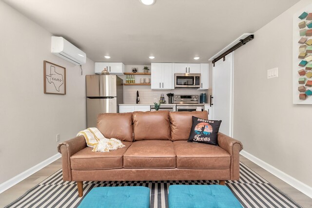 1747 Forest Hill Blvd, Houston, TX 77023 - living room featuring a wall mounted AC, recessed lighting, a barn door, baseboards, and light wood-style flooring