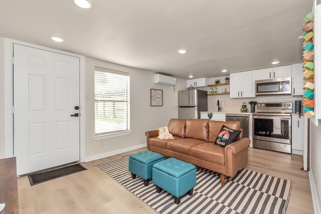 1747 Forest Hill Blvd, Houston, TX 77023 - living room with a wall mounted air conditioner, light wood finished floors, baseboards, and recessed lighting