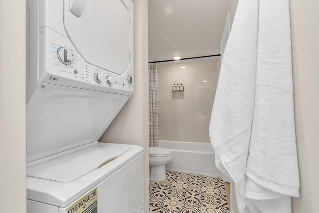full bathroom featuring toilet, stacked washer and dryer, tile patterned floors, and shower / bath combination with curtain