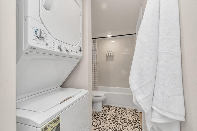1747 Forest Hill Blvd, Houston, TX 77023 - full bathroom featuring tile patterned floors, shower / bath combo with shower curtain, toilet, and stacked washer / drying machine