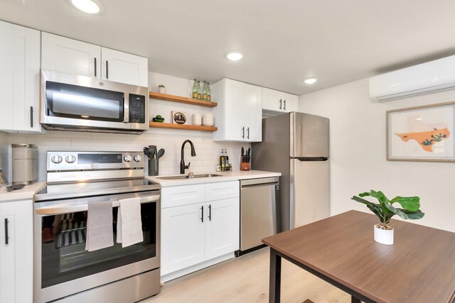 1747 Forest Hill Blvd, Houston, TX 77023 - kitchen with stainless steel appliances, a wall unit AC, tasteful backsplash, a sink, and white cabinetry