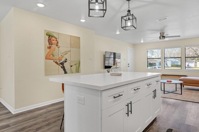 kitchen with baseboards, dark wood-style flooring, visible vents, open floor plan, and light countertops