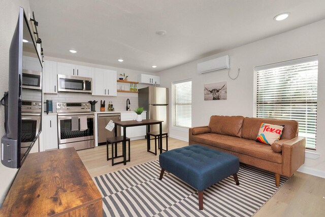 1747 Forest Hill Blvd, Houston, TX 77023 - living area with a wall unit AC, light wood finished floors, baseboards, and recessed lighting