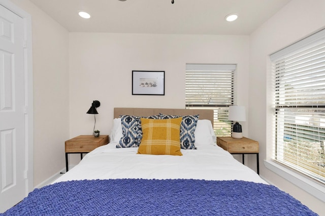 bedroom featuring multiple windows, baseboards, and recessed lighting