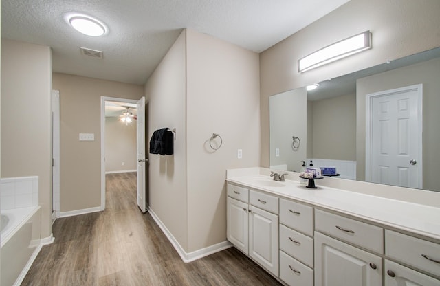 1211 Reedpoint Dr, Houston, TX 77090 - bathroom with a garden tub, visible vents, vanity, wood finished floors, and a ceiling fan