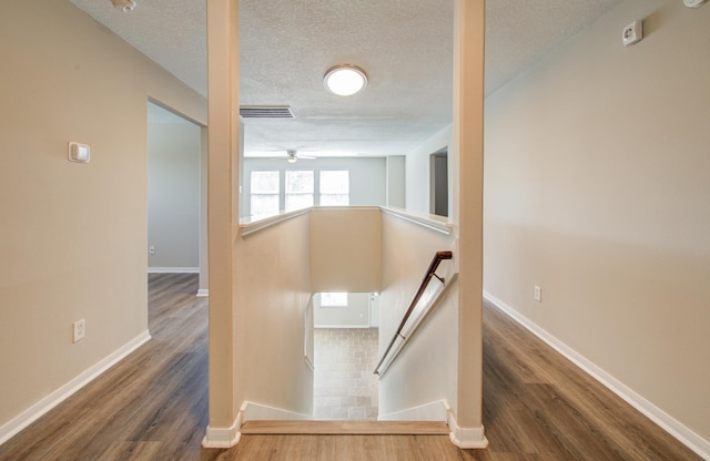 1211 Reedpoint Dr, Houston, TX 77090 - stairs with a textured ceiling, a ceiling fan, baseboards, wood finished floors, and visible vents