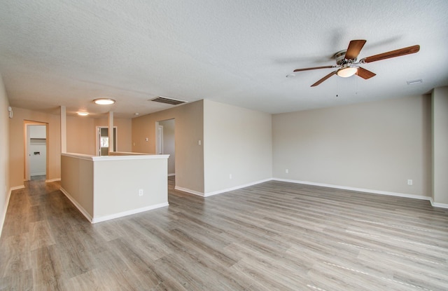 1211 Reedpoint Dr, Houston, TX 77090 - unfurnished living room with visible vents, a textured ceiling, ceiling fan, and wood finished floors