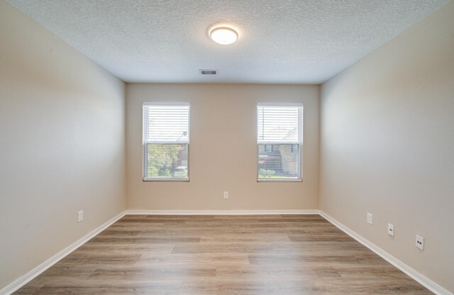 1211 Reedpoint Dr, Houston, TX 77090 - unfurnished room featuring a wealth of natural light, light wood-style flooring, a textured ceiling, and visible vents