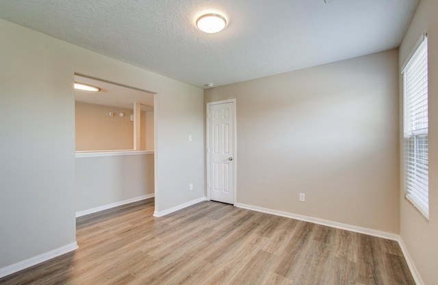 1211 Reedpoint Dr, Houston, TX 77090 - empty room featuring a textured ceiling, baseboards, and wood finished floors